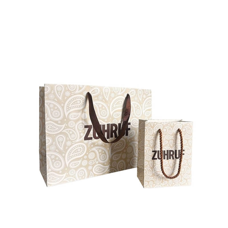 Two sizes of paper grocery bags with brown handles and printed logo